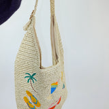 Woven handbag with tropical designs on a white background