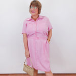 Woman wearing a pink outfit with a white background