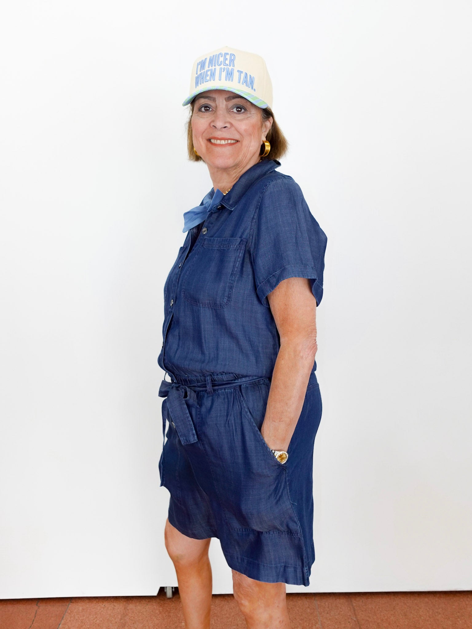 Woman wearing a blue dress and white cap with text against a white background