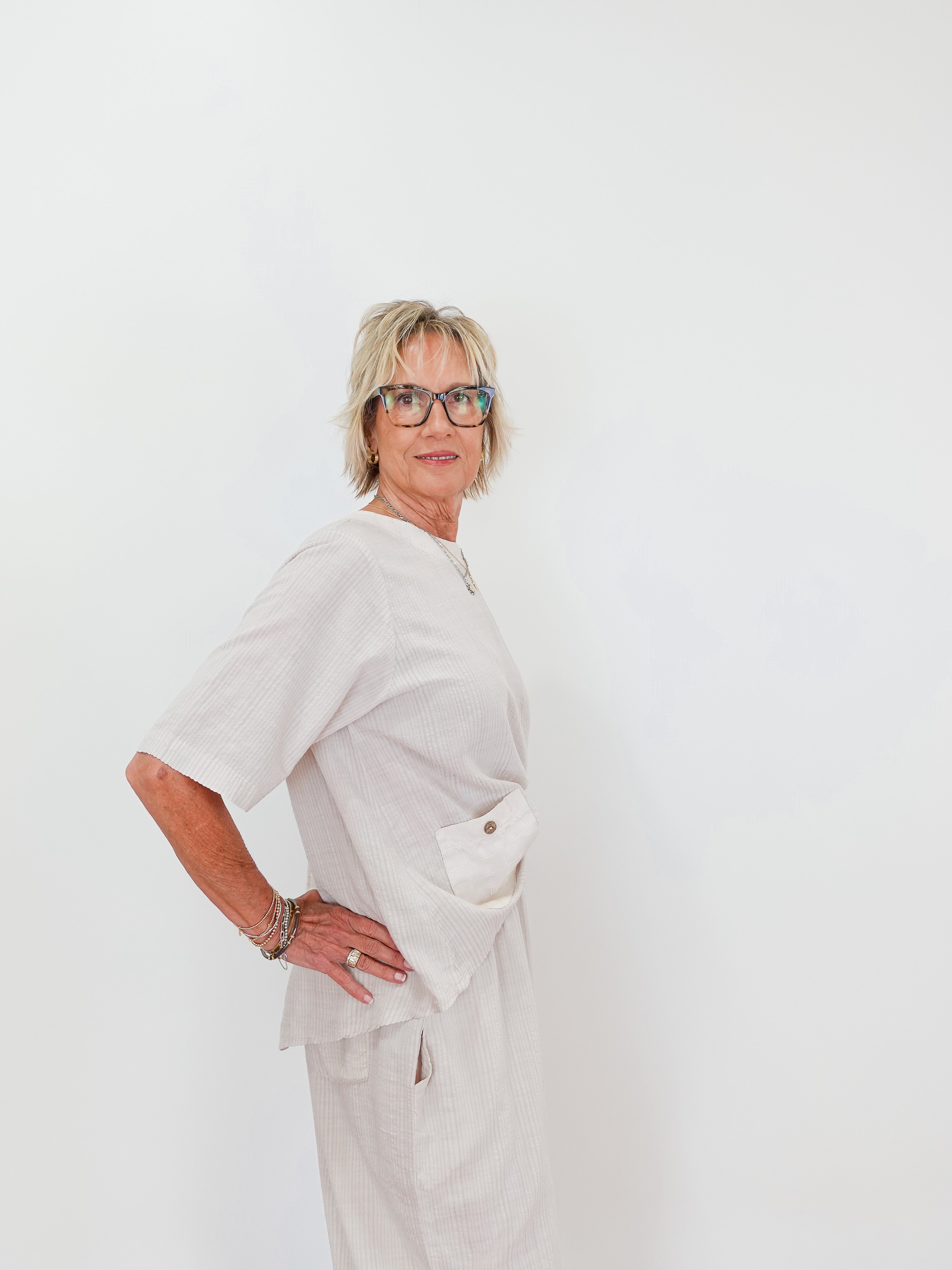 Person wearing a white outfit with a plain background