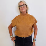 Woman wearing a brown top with buttons against a white background