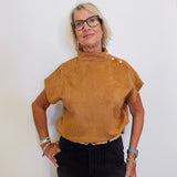 Woman wearing a brown top with buttons against a white background