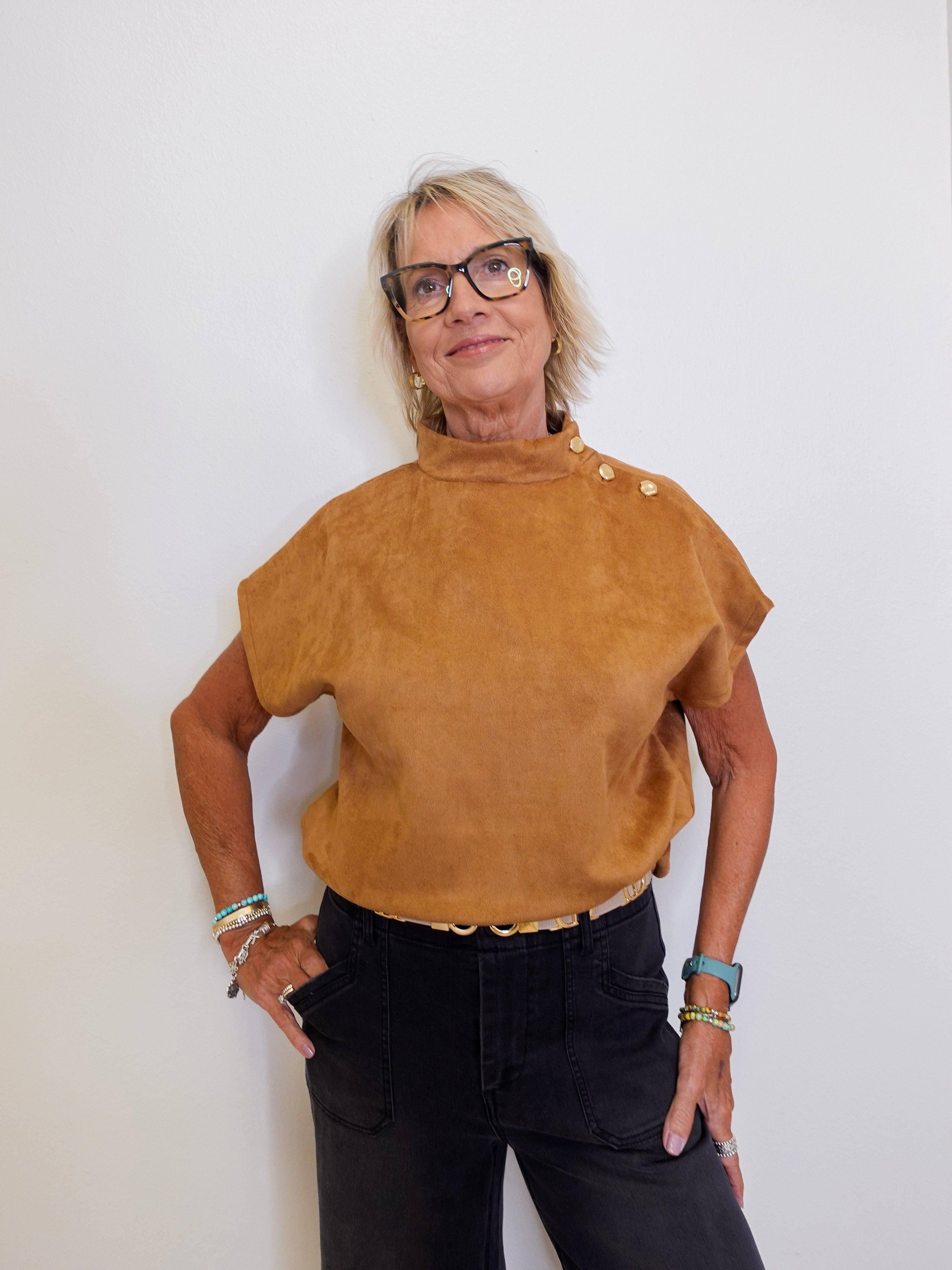 Woman wearing a brown top with buttons against a white background