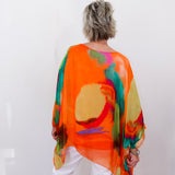 Person wearing a colorful, abstract-patterned orange garment against a white background