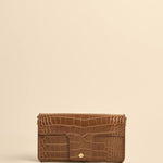 Brown crocodile-patterned wallet on a beige background