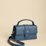 Blue handbag with a strap on a beige background