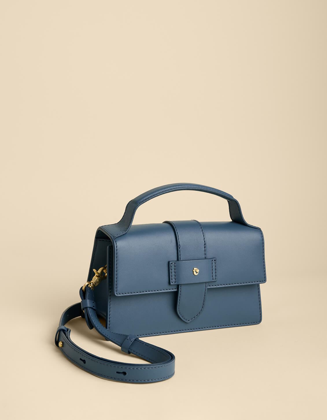 Blue handbag with a strap on a beige background