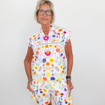Woman wearing a colorful floral dress against a white background