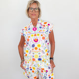 Woman wearing a colorful floral dress against a white background