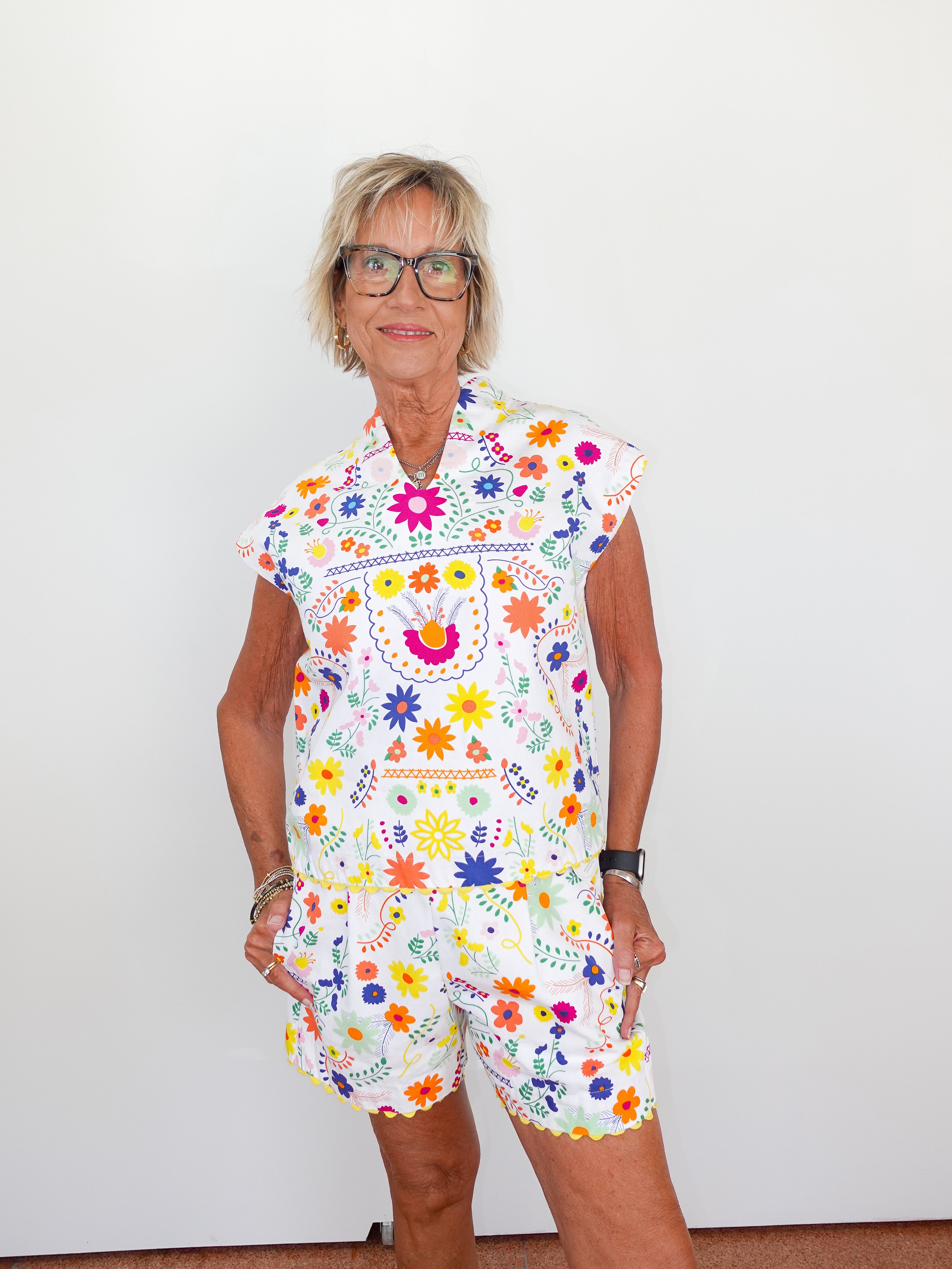 Woman wearing a colorful floral dress against a white background