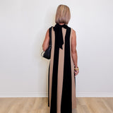 Woman wearing a versatile sleeveless colorblock maxi dress for women against a white background. 