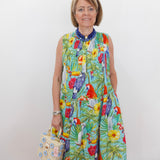 Woman wearing a colorful parrot print dress against a white background
