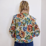 Person wearing a floral jacket with a plain white background