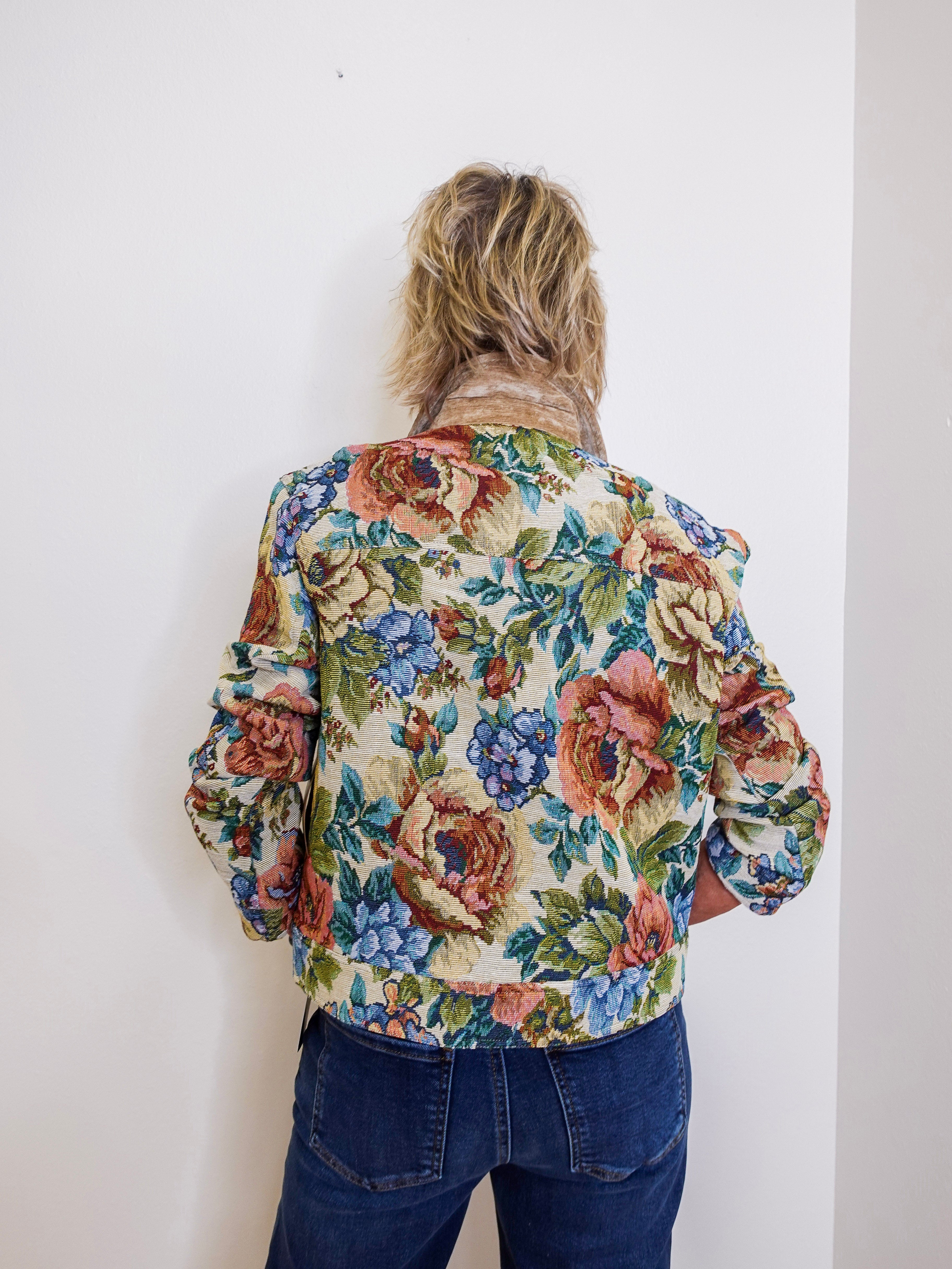 Person wearing a floral jacket with a plain white background