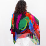 Person wearing a colorful, abstract-patterned shawl on a white background