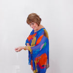 Woman wearing a colorful scarf against a white background