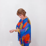 Woman wearing a colorful scarf against a white background