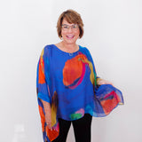 Woman wearing a colorful blouse with a white background