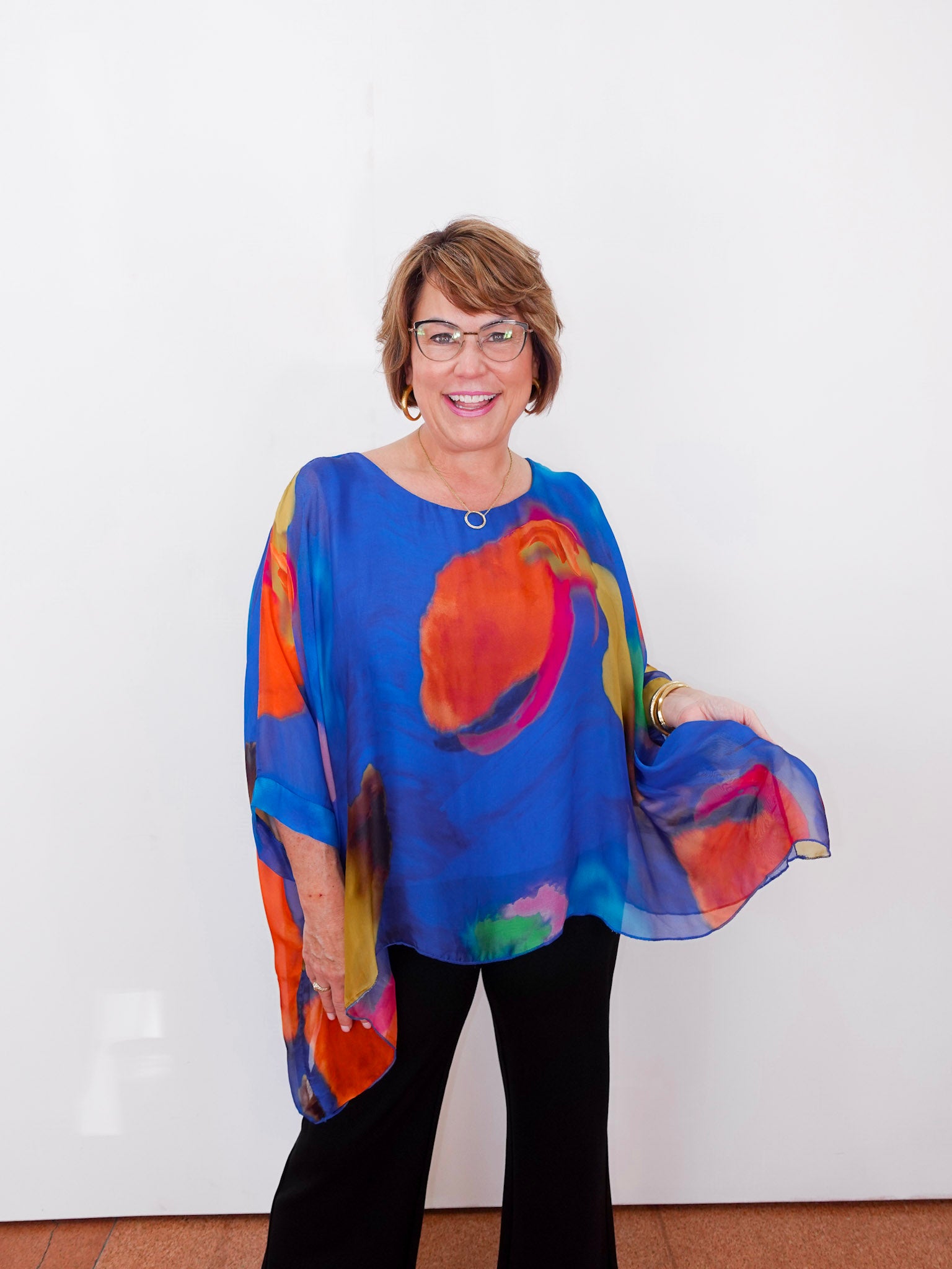 Woman wearing a colorful blouse with a white background