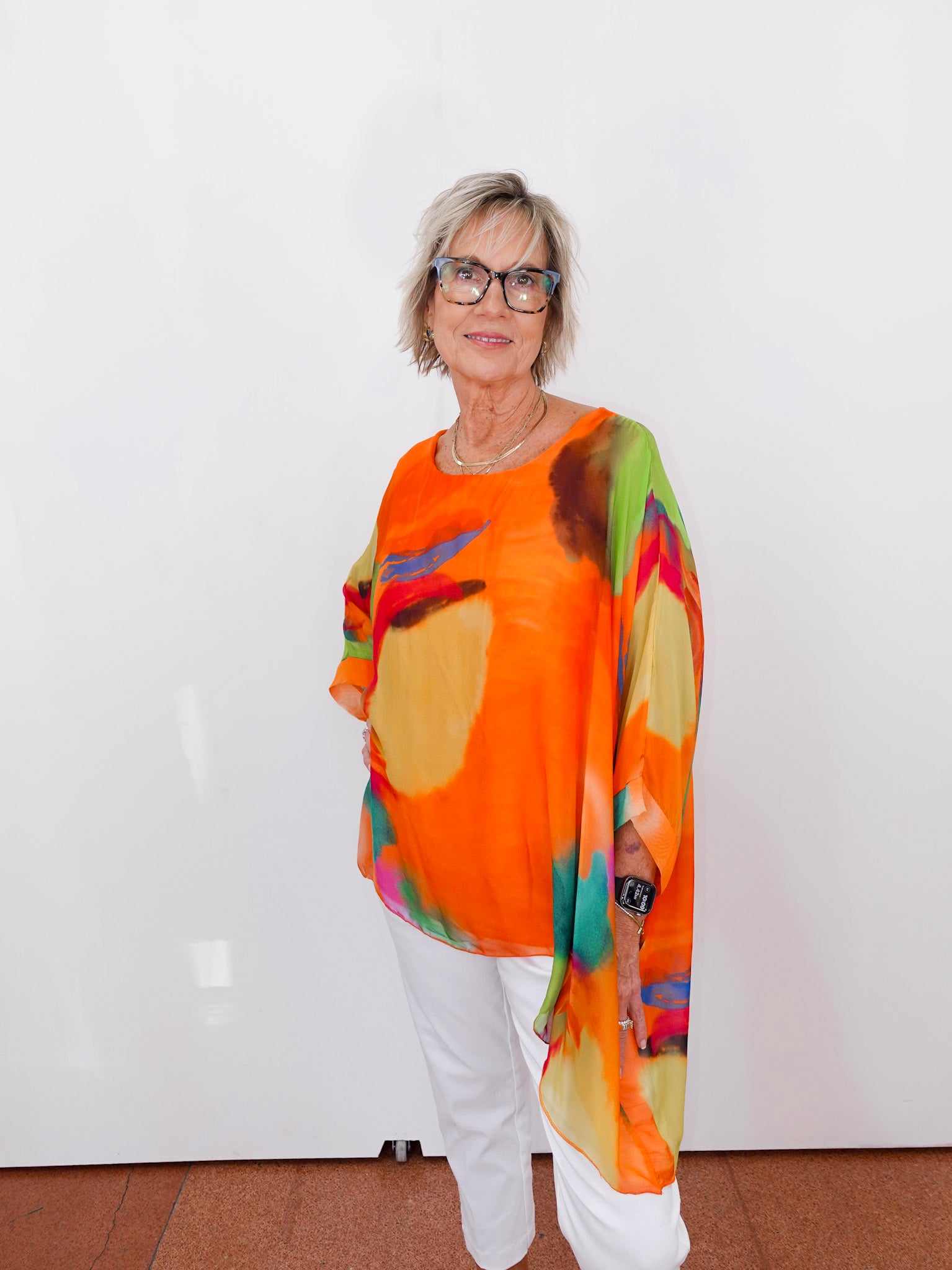 Person wearing a colorful, patterned shirt with an orange background.