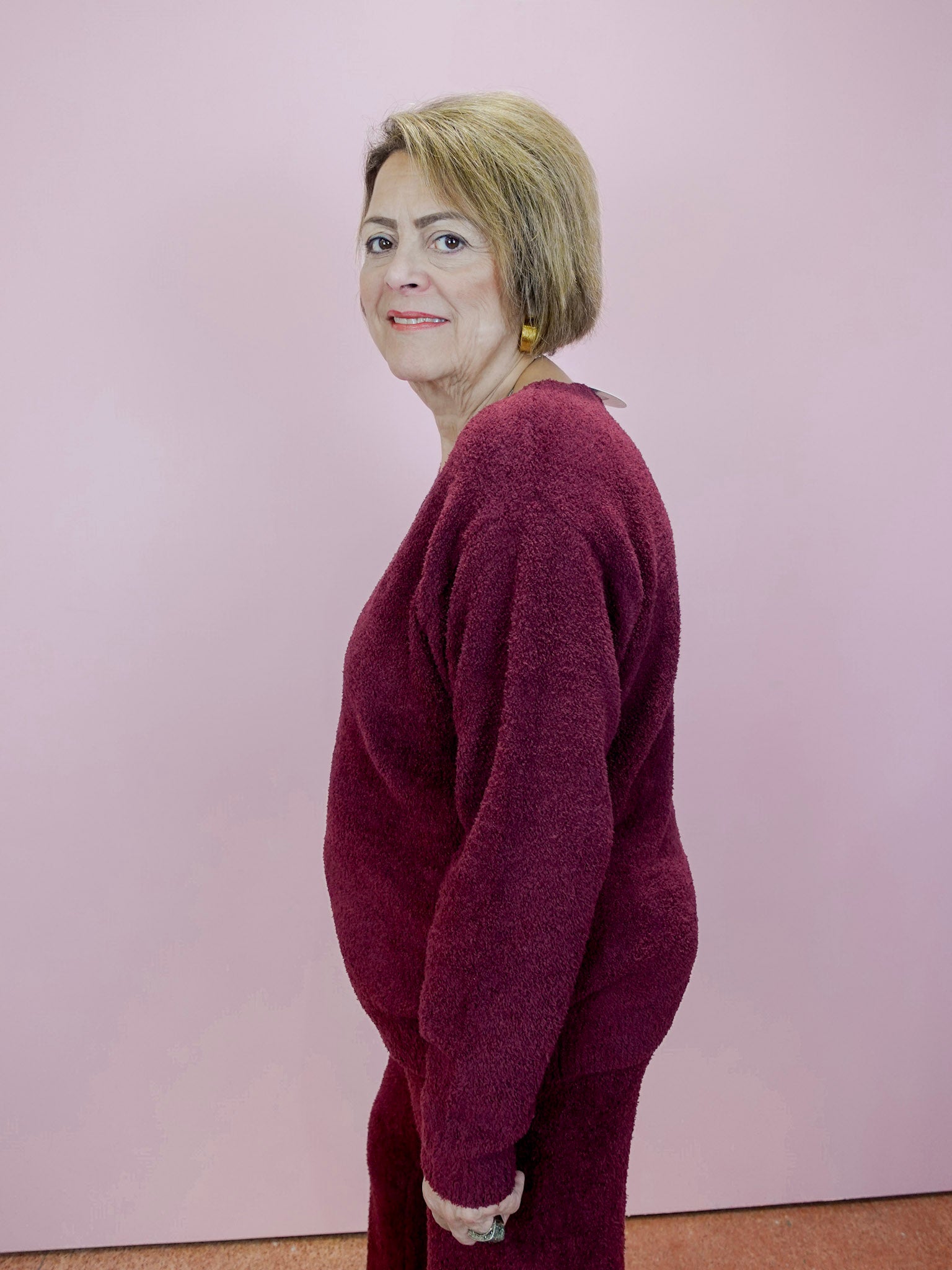 Woman wearing a burgundy outfit against a plain background