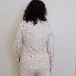 Person wearing a leopard print pajama set against a plain background