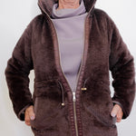 Person wearing a brown fleece jacket on a white background
