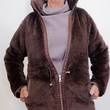 Person wearing a brown fleece jacket on a white background