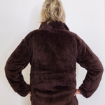 Person wearing a brown fleece jacket against a white background