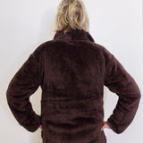 Person wearing a brown fleece jacket against a white background