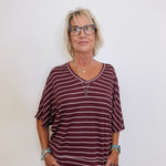 Person wearing a maroon and white striped outfit against a plain background