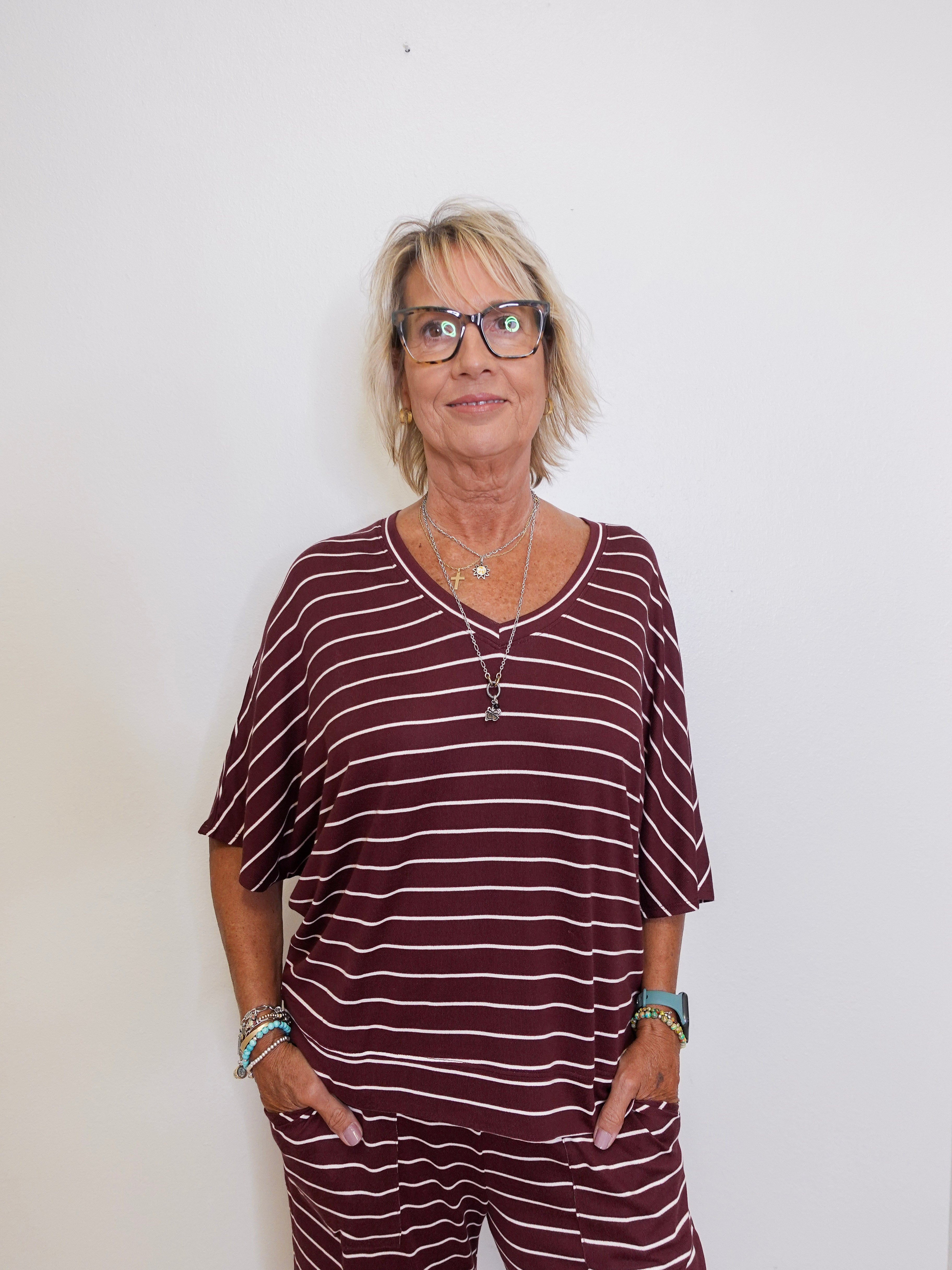 Person wearing a maroon and white striped outfit against a plain background