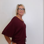 Woman wearing a burgundy dress against a plain background