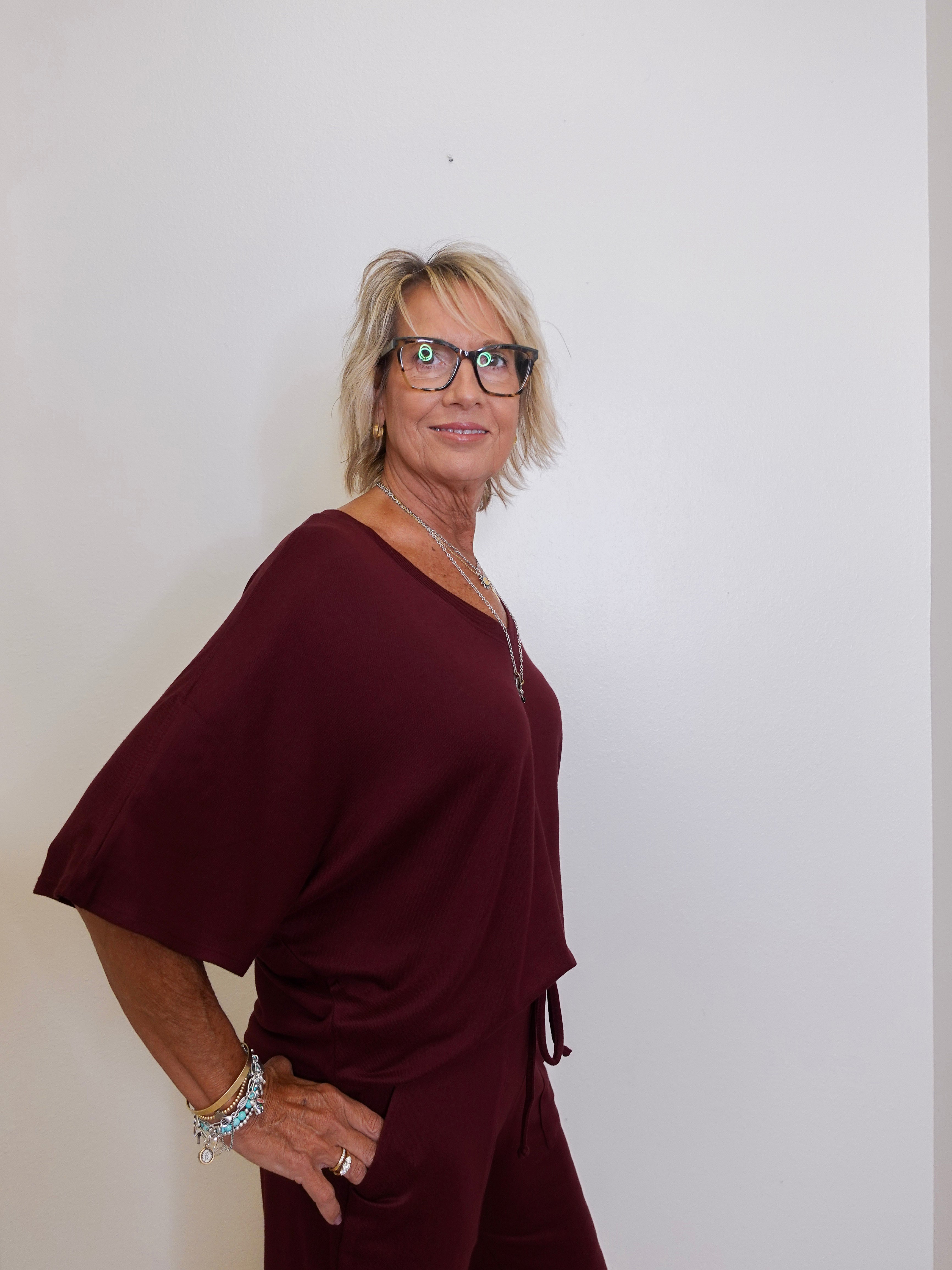Woman wearing a burgundy dress against a plain background
