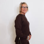Woman wearing a brown outfit against a white background