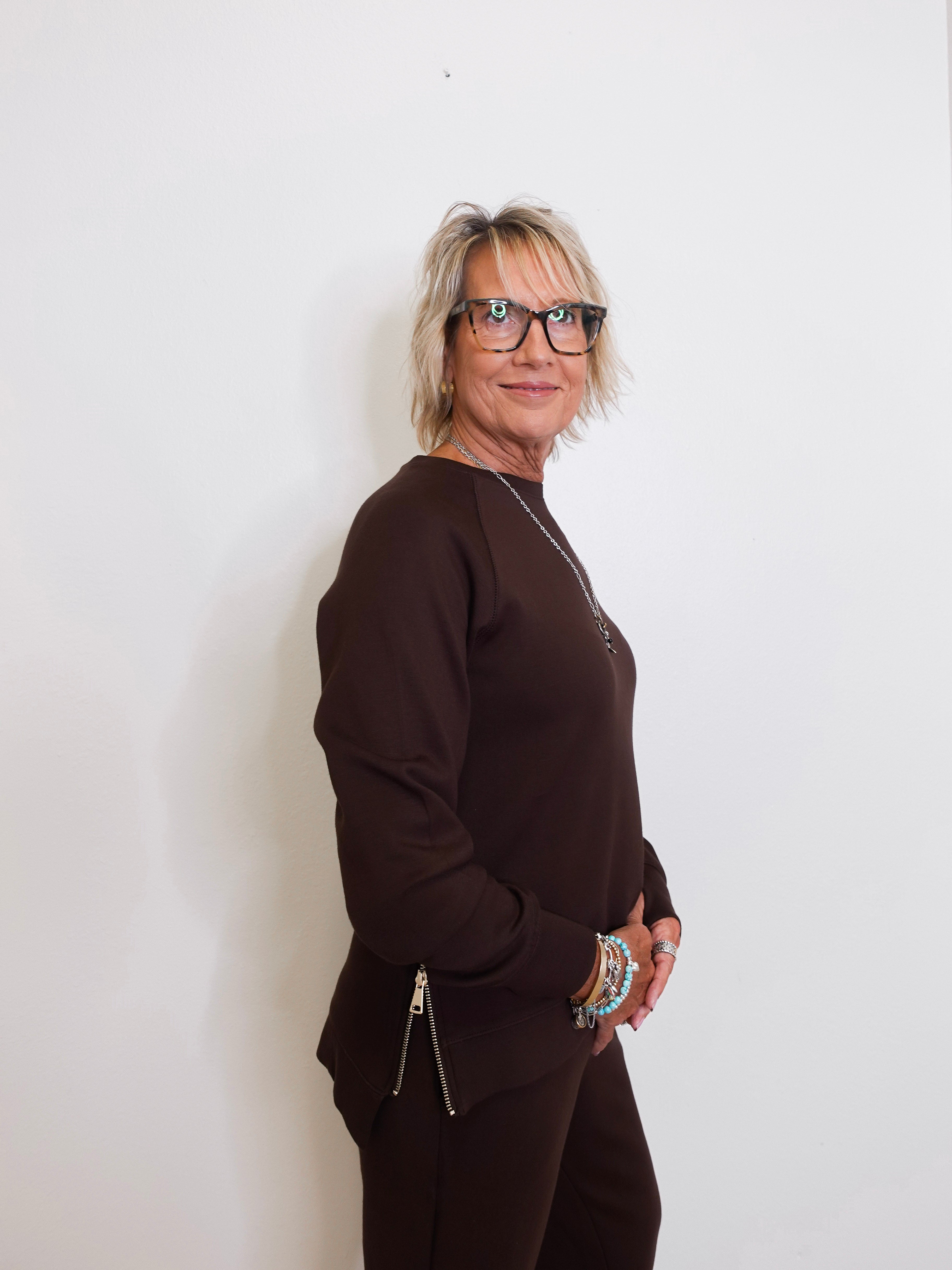 Woman wearing a brown outfit against a white background