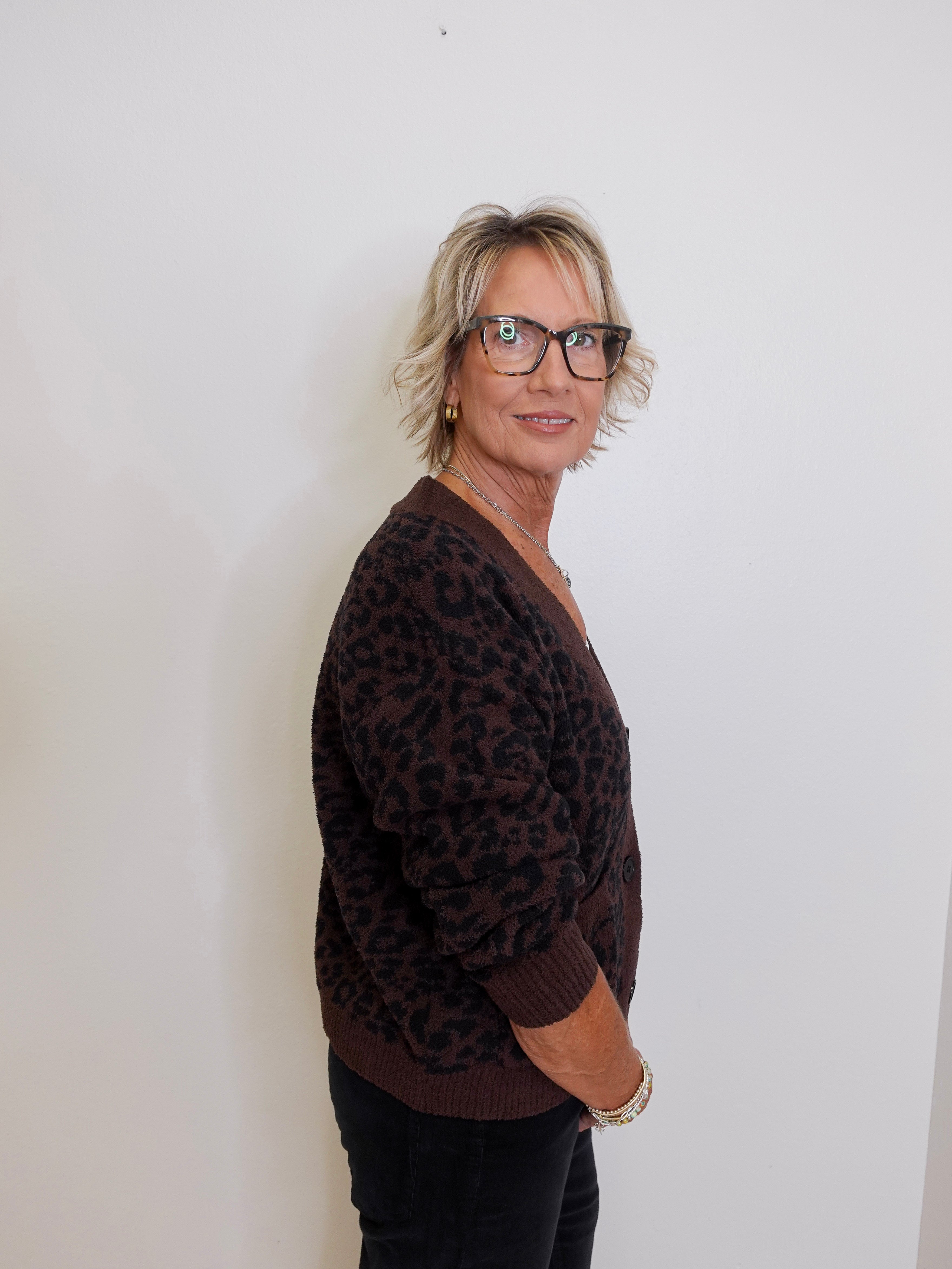 Person wearing a brown leopard print sweater against a white background