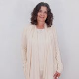 Woman wearing a beige outfit against a white background