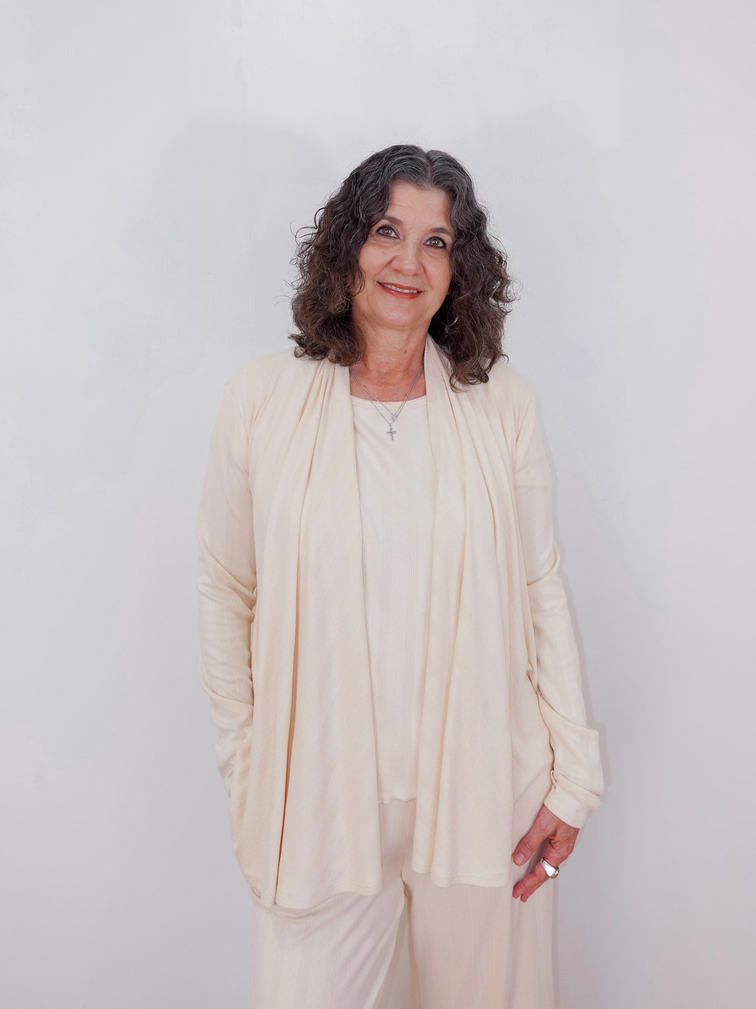 Woman wearing a beige outfit against a white background