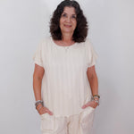 Woman wearing a white outfit against a plain background