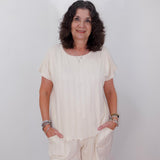 Woman wearing a white outfit against a plain background