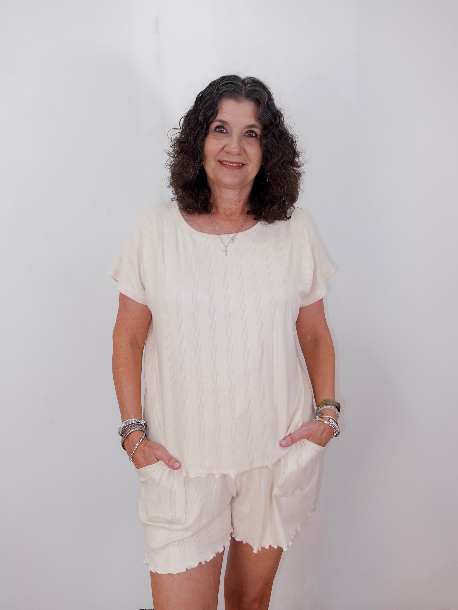 Woman wearing a white outfit against a plain background