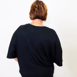 Person wearing a black t-shirt against a white background