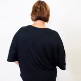Person wearing a black t-shirt against a white background