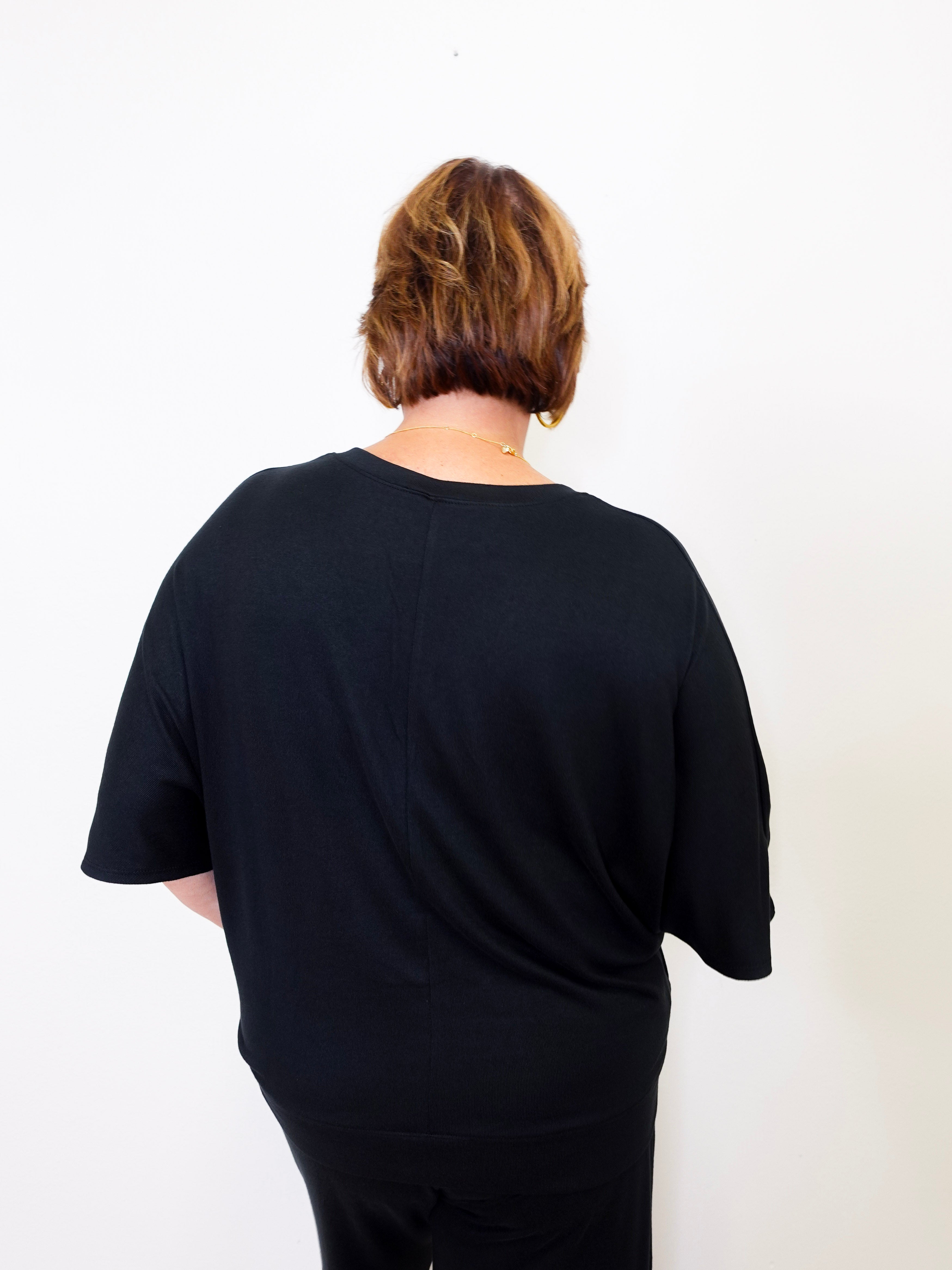 Person wearing a black t-shirt against a white background