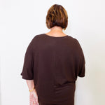 Person wearing a brown outfit against a white background