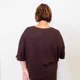 Person wearing a brown outfit against a white background