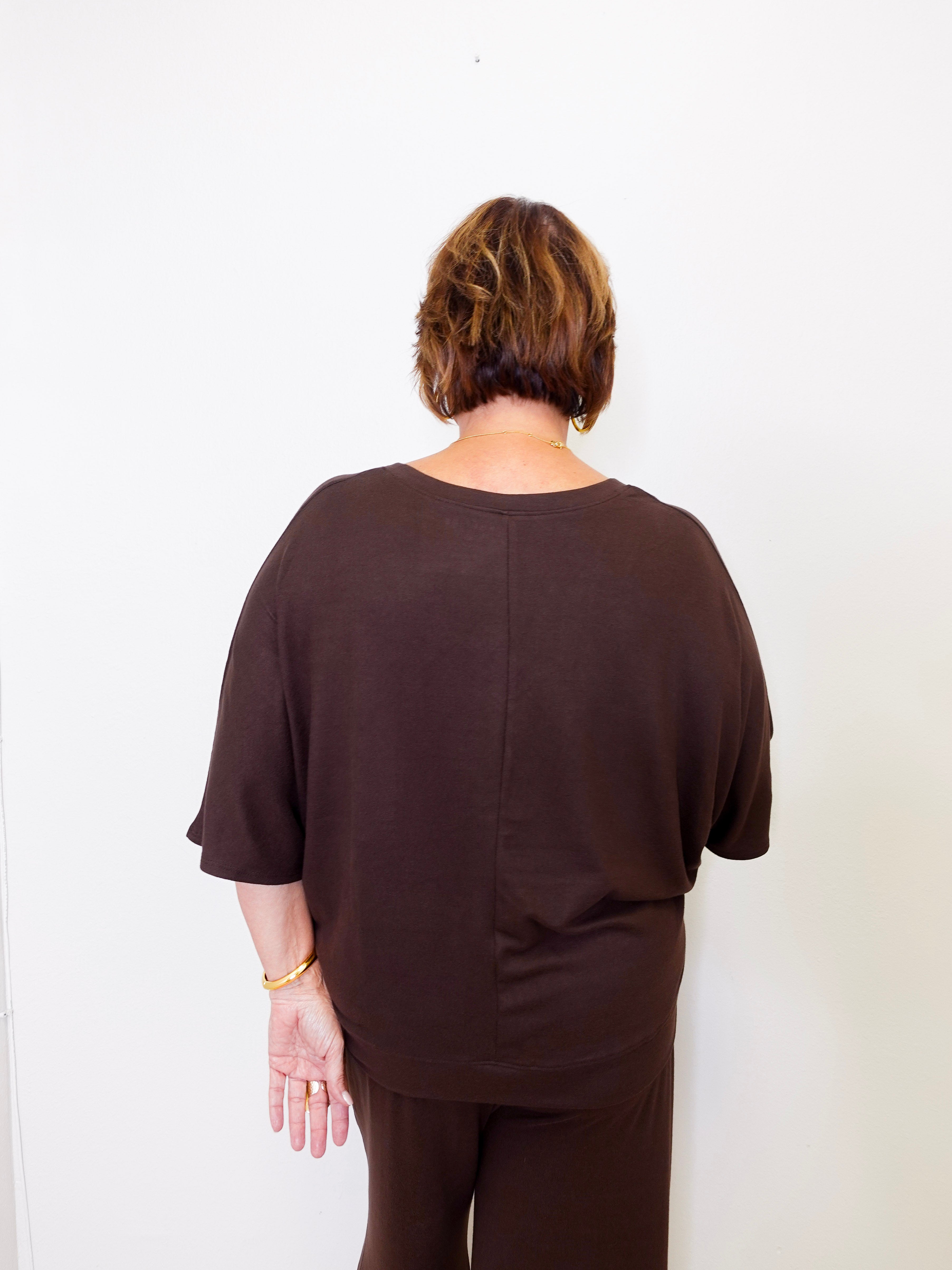 Person wearing a brown outfit against a white background