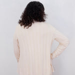 Person wearing a beige outfit against a white background