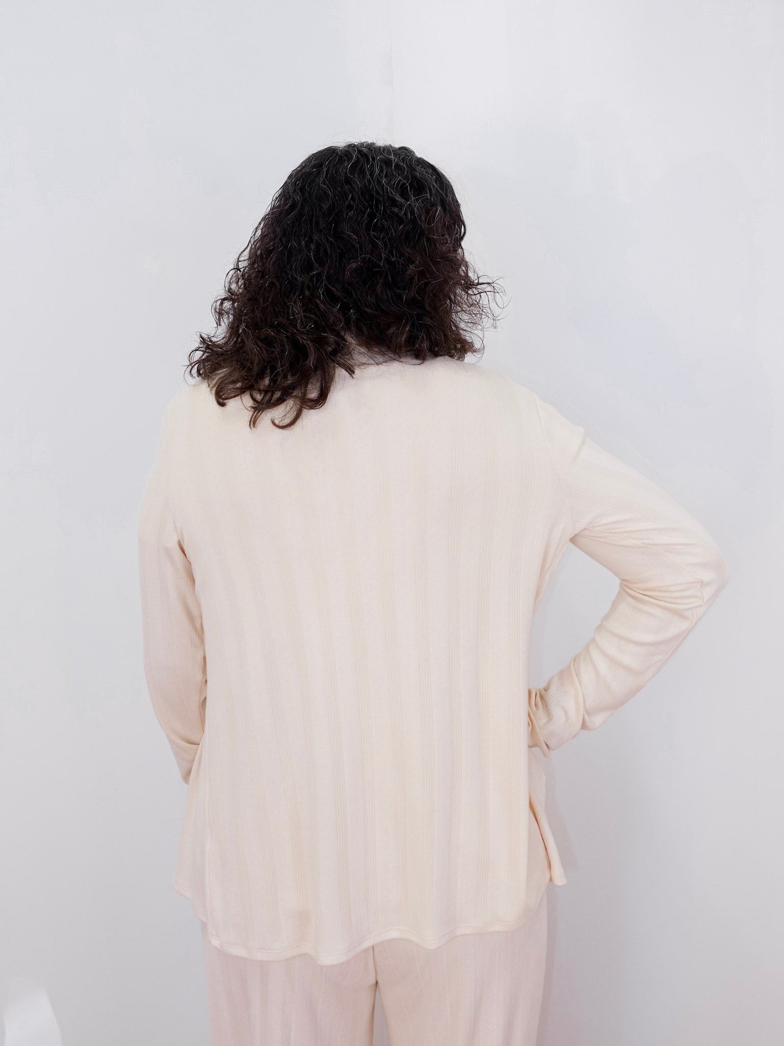 Person wearing a beige outfit against a white background